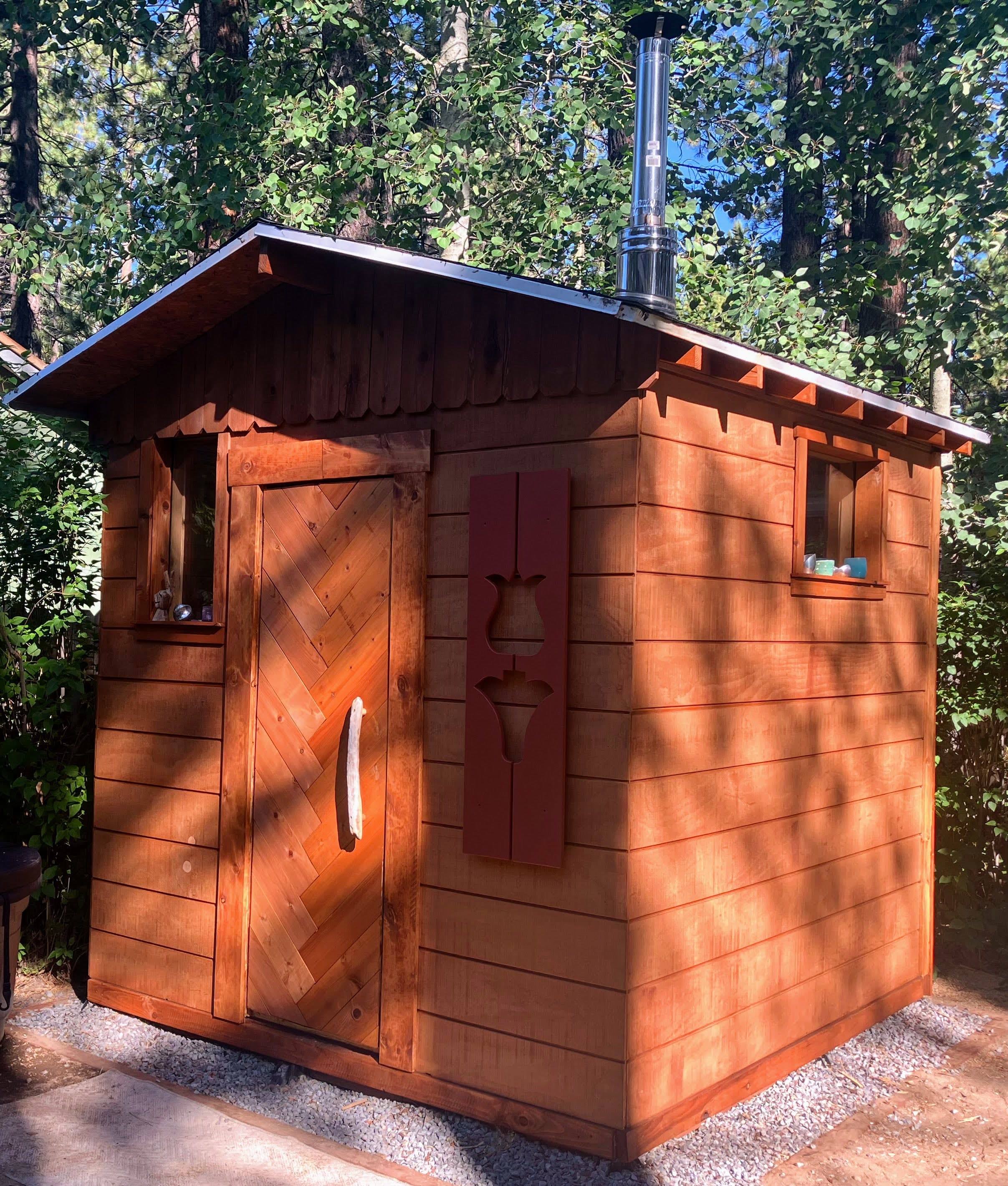 Wood-fired sauna bench layout and heater placement