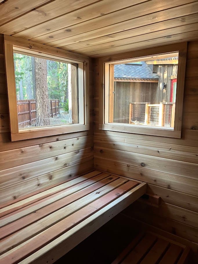 Two cedar-framed windows placed for forest views and privacy from the neighbors, above a lower cedar bench