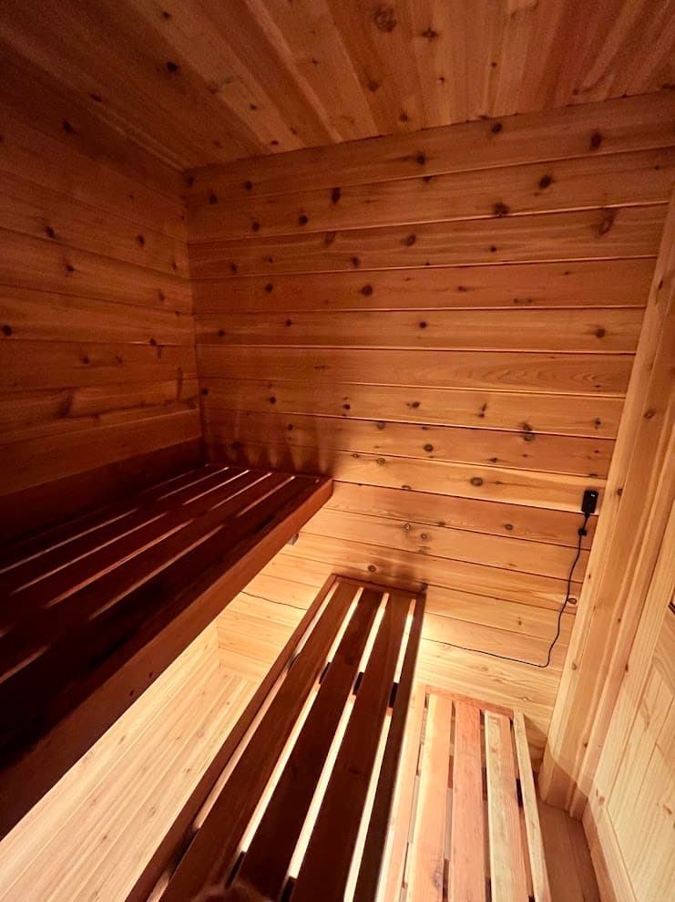 Interior view showing cedar paneling, two-tier redwood benches, and fan speed controller mounted on wall