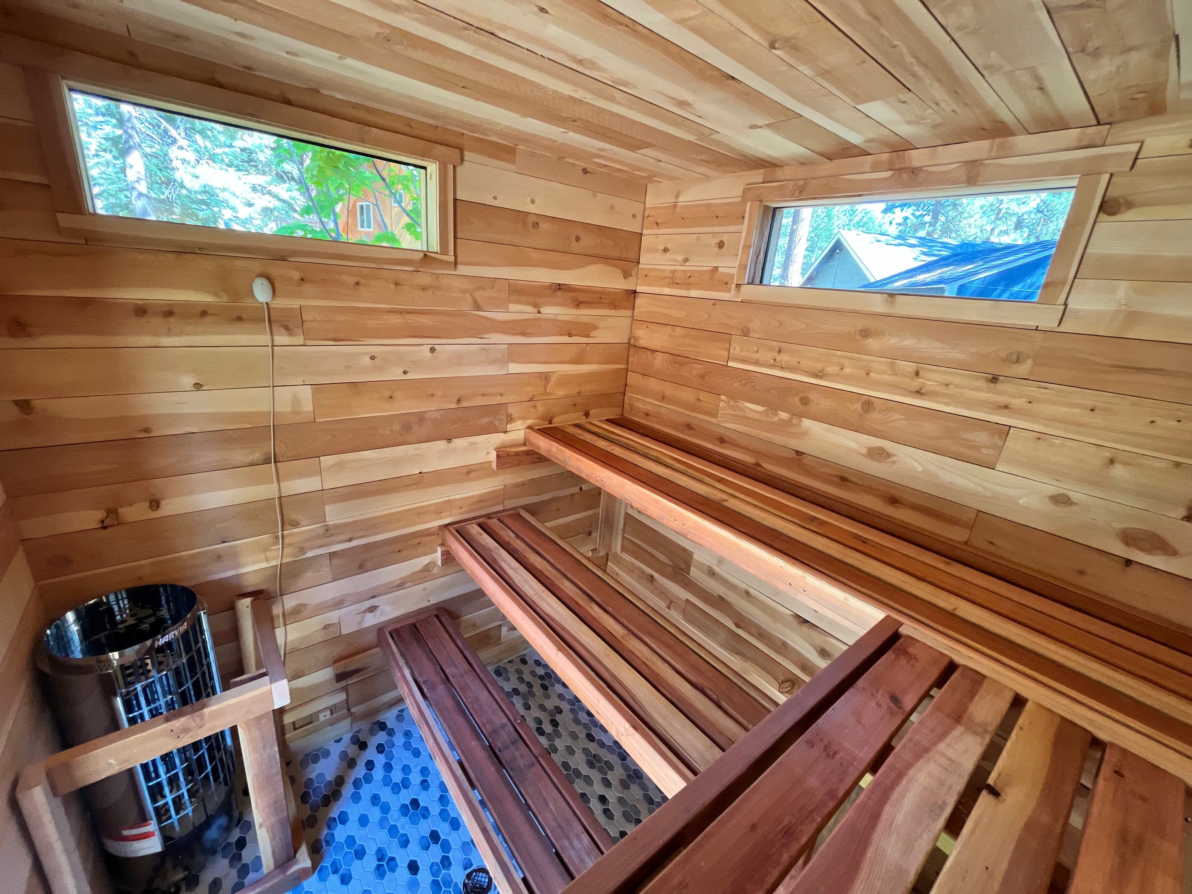 Completed 8x8 outdoor sauna with dark brown stained cedar exterior blending into landscaping – South Lake Tahoe