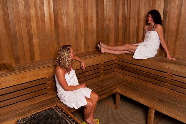 Gym sauna renovation — sauna interior with multi-tier wooden benches and heater