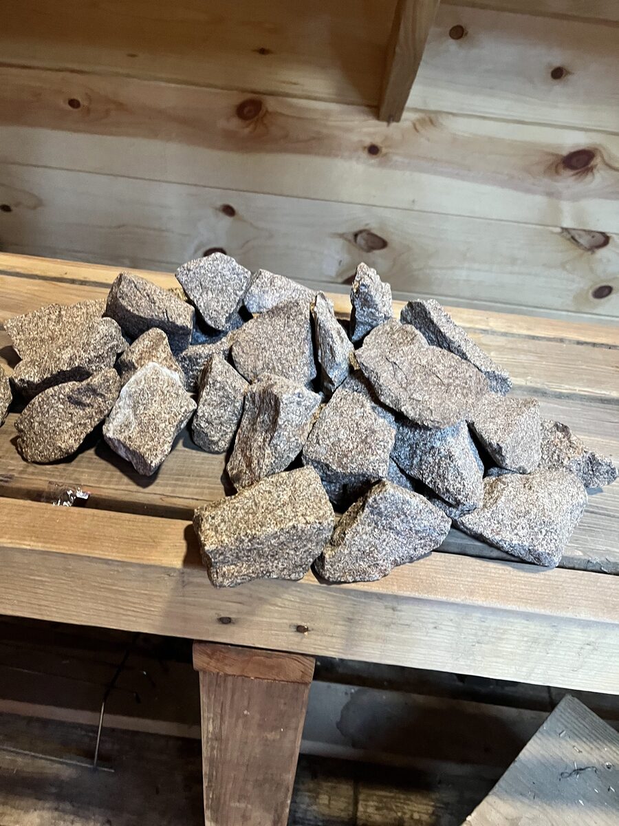 Removing the sauna stones from the heater to expose the elements