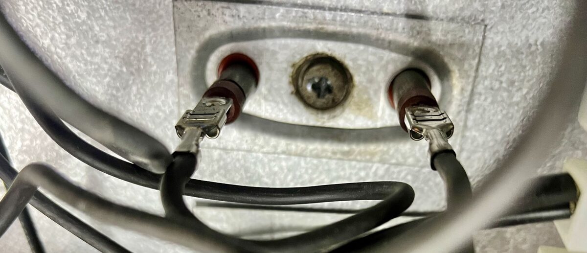 Unscrewing the element's mounting bracket and terminals from the bottom of the heater