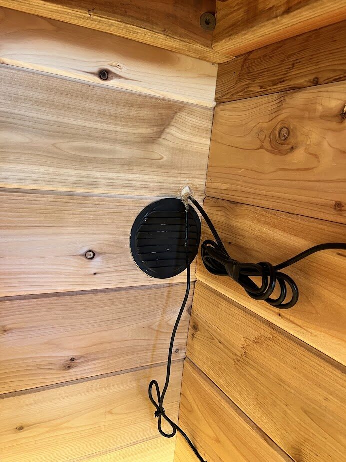 The finished interior exhaust vent cover mounted on the sauna wall